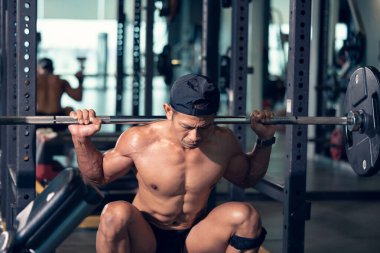 Sportif vücut geliştirici ya da halterci spor salonunda halterle ağırlık kaldırma egzersizi yapıyor. Spor salonunda spor yapmak..