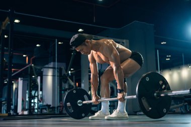Sportif vücut geliştirici ya da halterci spor salonunda halterle ağırlık kaldırma egzersizi yapıyor. Spor salonunda spor yapmak..