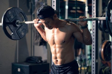 Sportif vücut geliştirici ya da halterci spor salonunda halterle ağırlık kaldırma egzersizi yapıyor. Spor salonunda spor yapmak..
