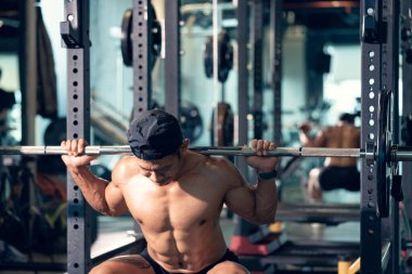 Sportif vücut geliştirici ya da halterci spor salonunda halterle ağırlık kaldırma egzersizi yapıyor. Spor salonunda spor yapmak..