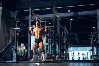 Sportif vücut geliştirici ya da halterci spor salonunda halterle ağırlık kaldırma egzersizi yapıyor. Spor salonunda spor yapmak..