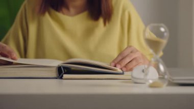 Evdeki masada kitap okuyan Asyalı kadını yakından çek. Yaşam tarzı ve eğitim kavramı.