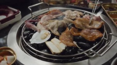 Lokantada Kore barbeküsünde ızgara domuz eti ve ızgara ızgara et. Geleneksel Kore usulü ızgara ızgarada domuz eti..