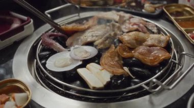 Lokantada Kore barbeküsünde ızgara domuz eti ve ızgara ızgara et. Geleneksel Kore usulü ızgara ızgarada domuz eti..