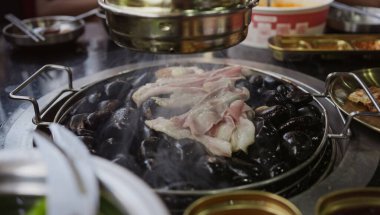 Lokantada Kore barbeküsünde ızgara domuz eti ve ızgara ızgara et. Geleneksel Kore usulü ızgara ızgarada domuz eti..