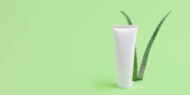 Arkaplanda aloe vera bulunan boş kozmetik tüpü. Organik kozmetik konsepti, büyük afiş..