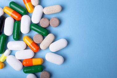 Mavi arkaplandaki farklı hapların üst görünümü, metin için alanı kopyala.