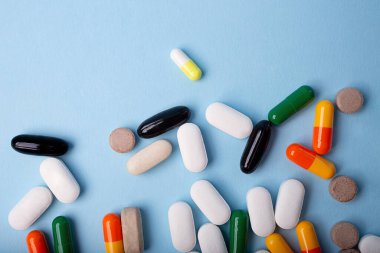 Mavi arkaplandaki farklı hapların üst görünümü, metin için alanı kopyala.