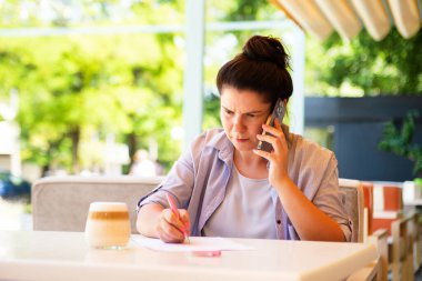 Serious bussines woman with smartphone,signed document.