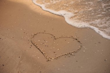 Heart drawing on sea sand,natural background.