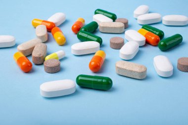 Front view of different pills on blue background,copy space for text.Large banner with negative space.