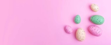 Frame from multicolored eggs on pink background,Easter concept.Large banner with negative space.