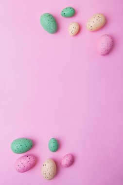 Pembe arka planda çok renkli yumurtaların dikey çerçevesi. Paskalya konsepti.