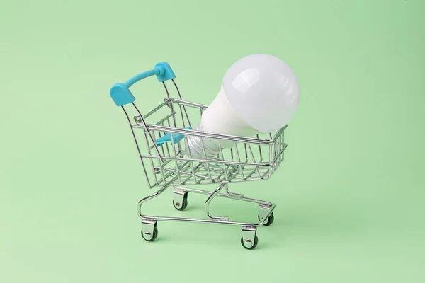緑の背景にショッピングカートのLed電球 — ストック写真