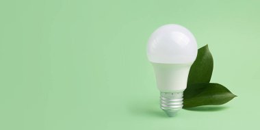 Led bulb with frsh green leafs,green energy concept.Large banner with negative space. clipart