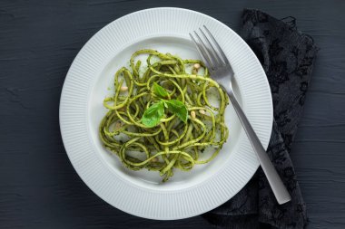 Spagetti Makarna ile pesto sosu, fesleğen, çam fıstığı ve parmesan üstten görünüm.