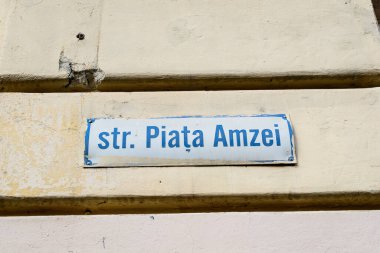 Romanya 'nın Bükreş kentindeki eski bir şehir merkezinde güneşli bir günde Strada Piata Amzei' yi (Amzei Market Caddesi) gösteren güzel bir klasik sokak tabelası