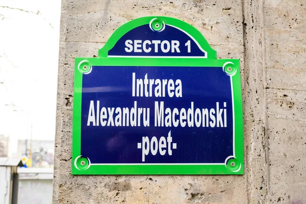 Beautiful vintage street sign showing Entrance Alexandru Macedonski (Intrarea Alexandru Macedonski) displayed on an street in the old city center of Bucharest, Romania, in a sunny day