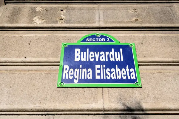 Beautiful vintage street sign showing Bulevardul Regina Elisabeta (Regina Elisabeta Boulevard) displayed on an street in the old city center of Bucharest, Romania, in a sunny day with clear blue sky