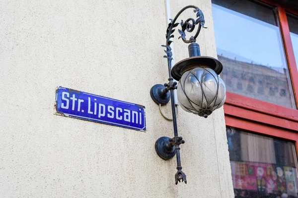 Beautiful vintage street sign showing Strada Lipscani (Lipscani Street) displayed on an street in the old city center of Bucharest, Romania, in a sunny day with clear blue sky