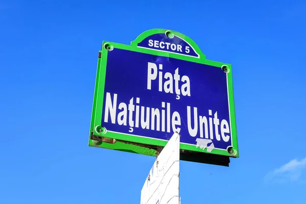 Beautiful vintage street sign showing Piata Natiunile Unite (United Nations Square) displayed on an street in the city center of Bucharest, Romania, in a sunny day with clear blue sky