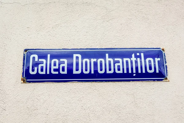 Beautiful vintage street sign showing Calea Dorobantilor (Dorobantilor Avenue) displayed on an street in the old city center of Bucharest, Romania, in a sunny day with clear blue sky