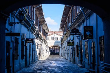 Bükreş, Romanya, 2 Ocak 2022: Güneşli bir kış gününde tarihi merkezde, Lipscani Caddesi 'nde (Strada Lipscani) küçük dükkanları ve sanat galerisi bulunan Hanul cu tei eski binası
