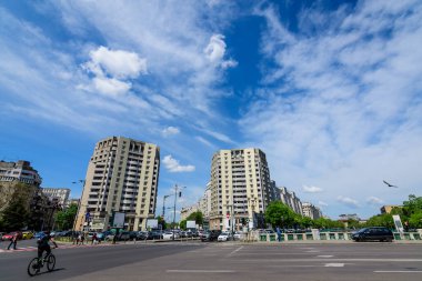 Bükreş, Romanya, 6 Mayıs 2021 - Natiunile Birleşik Meydanı (Piata Natiunile Birliği) yakınlarındaki modern binalar ve Dambovita nehri üzerindeki köprü ve şehrin merkezinde güneşli bir bahar gününde bulutlu mavi gökyüzü