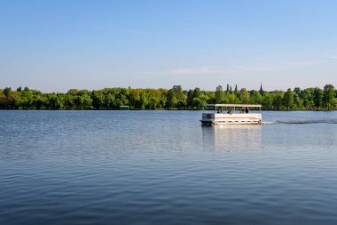 Bucharest, Romania - 5 May 2021:: Landscape with Herastrau lake and large green trees in King Michael I Park (Herastrau) in Bucharest, Romania,  in a sunny spring day