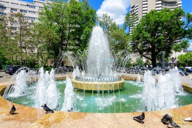 Bükreş, Romanya - 6 Mayıs 2021: Güneşli bir bahar gününde Üniversite Meydanı (Piata Universitatii) yakınlarında dekoratif su çeşmesi