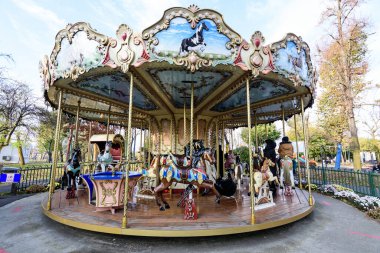 Bucharest, Romania, 13 November 2021: Colourful children colorful carousel with mixed plastic and metallic toys and materials in Parcul Tei (Linden Park) in a sunny autumn day