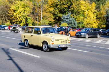 Bükreş, Romanya, 24 Ekim 2021: Güneşli bir sonbahar gününde, şehir merkezinde bir caddede trafikte canlı beyaz bir Trabant Alman klasik otomobili