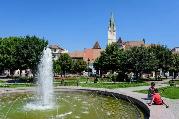 stock image Medias, Romania, 14 July 2021: City landscape with Ferdinand I King Square (Piata Regele Ferdinand I) and green park in the old city center, in Transylvania (Transilvania) region, Romania, in a sunny summer day