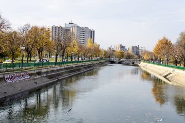 Bucharest, Romania, 6 November 2021: Modern buildings and offices near Dambovita river and cloudy blue sky in the center of the city, in a cloudy autumn day