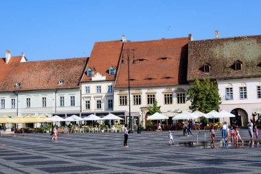 Sibiu, Romanya - 15 Temmuz 2021: Transilvanya 'daki Büyük Meydan' da (Piata Mare) güneşli bir yaz gününde yenilenen tarihi binalar