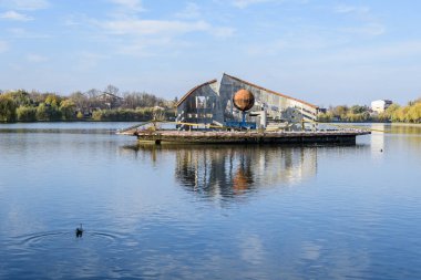 Plumbuita Gölü (Lacul Plumbuita) üzerindeki dekoratif fıskiyeli manzara ve Romanya 'nın Bükreş kentinde güneşli bir sonbahar gününde beyaz bulutlar ve mavi gökyüzü