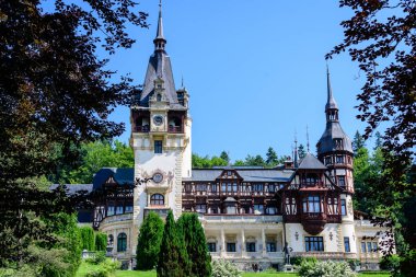 Romanya 'nın Sinaia kentinde güneşli bir yaz gününde Bucegi Dağları (Muntii Bucegi) yakınlarındaki Peles Kalesi' nin (Castelul Peles) güzel neo-rönesans binası