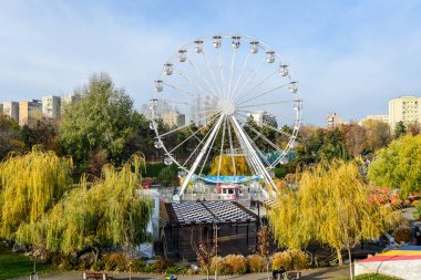 Bükreş, Romanya, 30 Kasım 2023: Mavi gökyüzüyle güneşli bir günde, Drumul Taberei yakınlarındaki Batı Yakası Noel Pazarı 'nda büyük tekerlek