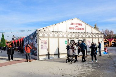 Bükreş, Romanya, 30 Kasım 2023: Mavi gökyüzü güneşli ve güneşli bir günde, Drumul Taberei yakınlarındaki Batı Yakası Noel Pazarı 'nda geleneksel ürünlerle dolu canlı renkli evler