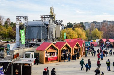 Bükreş, Romanya, 30 Kasım 2023: Mavi gökyüzü güneşli ve güneşli bir günde, Drumul Taberei yakınlarındaki Batı Yakası Noel Pazarı 'nda geleneksel ürünlerle dolu canlı renkli evler