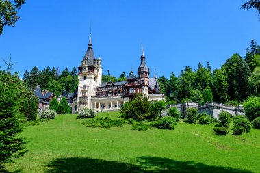 Romanya 'nın Sinaia kentinde güneşli bir yaz gününde Bucegi Dağları (Muntii Bucegi) yakınlarındaki Peles Kalesi' nin (Castelul Peles) güzel neo-rönesans binası
