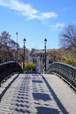 Romanya 'nın Bükreş kentindeki Dambovita nehri üzerindeki eski yeşil metalik paslı köprü, güneşli bir sonbahar gününde