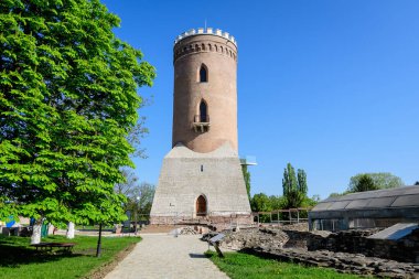 Chindia Kulesi veya Turnul Chindiei, Romanya 'da güneşli bir bahar gününde şehrin tarihi bir bölümünde, Çin Parkı' ndaki Targoviste Kraliyet Mahkemesi 'ndeki (Curtea Domneasca) eski bina ve kalıntılar