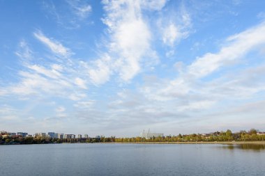 Romanya 'nın Bükreş kentinde, Linden Park' taki (Parcul Tei) ağaçlı manzara, güneşli bir sonbahar gününde beyaz bulutlar ve mavi gökyüzü