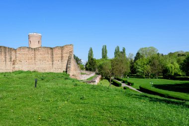 Chindia Kulesi veya Turnul Chindiei, Romanya 'da güneşli bir bahar gününde şehrin tarihi bir bölümünde, Çin Parkı' ndaki Targoviste Kraliyet Mahkemesi 'ndeki (Curtea Domneasca) eski bina ve kalıntılar