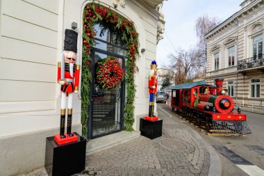 Romanya 'nın Bükreş şehir merkezinde güneşli bir kış gününde Noel tatili için süslenmiş canlı kırmızı Aziz Niklas treni