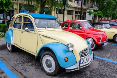 Craiova, Romanya, 29 Mayıs 2022: Canlı sarı ve mavi renkli bir Citroen Fransız klasik otomobili, güneşli bir bahar gününde klasik araba koleksiyonları etkinliğinde bir caddeye park etti
