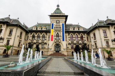 Craiova, Romanya, 29 Mayıs 2022: Romanya 'nın Dolj ilinin eski merkezindeki Craiova İdari Sarayı' nın tarihi binası beyaz bulutlarla dolu bir bahar günü