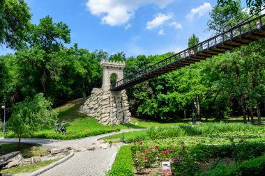 Craiova, Romanya, 28 Mayıs 2022: Romanya 'nın Dolj ilinin Craiova kentindeki Nicolae Romaescu parkında güzel güneşli bir bahar gününde askıya alınmış metalik köprü