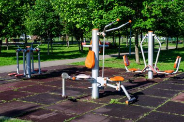 Romanya 'nın Bükreş kentinde güneşli bir bahar gününde, bir şehir parkındaki spor ve etkinlikler için açık hava fitness makinesi